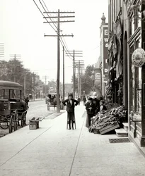 Un ragazzo con trampoli davanti al mercato F.J. Voepel al 4874 Easton Avenue, all